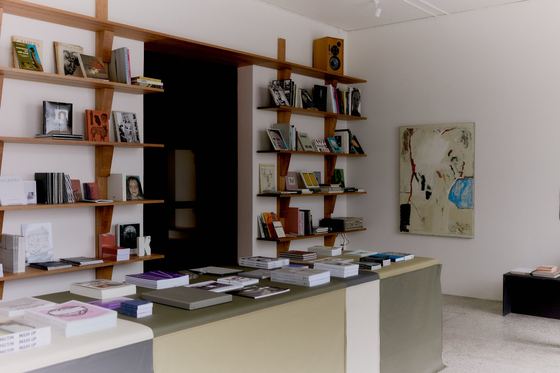 The main room: cherry-wood shelving, the leather counter and a painting on the far wall