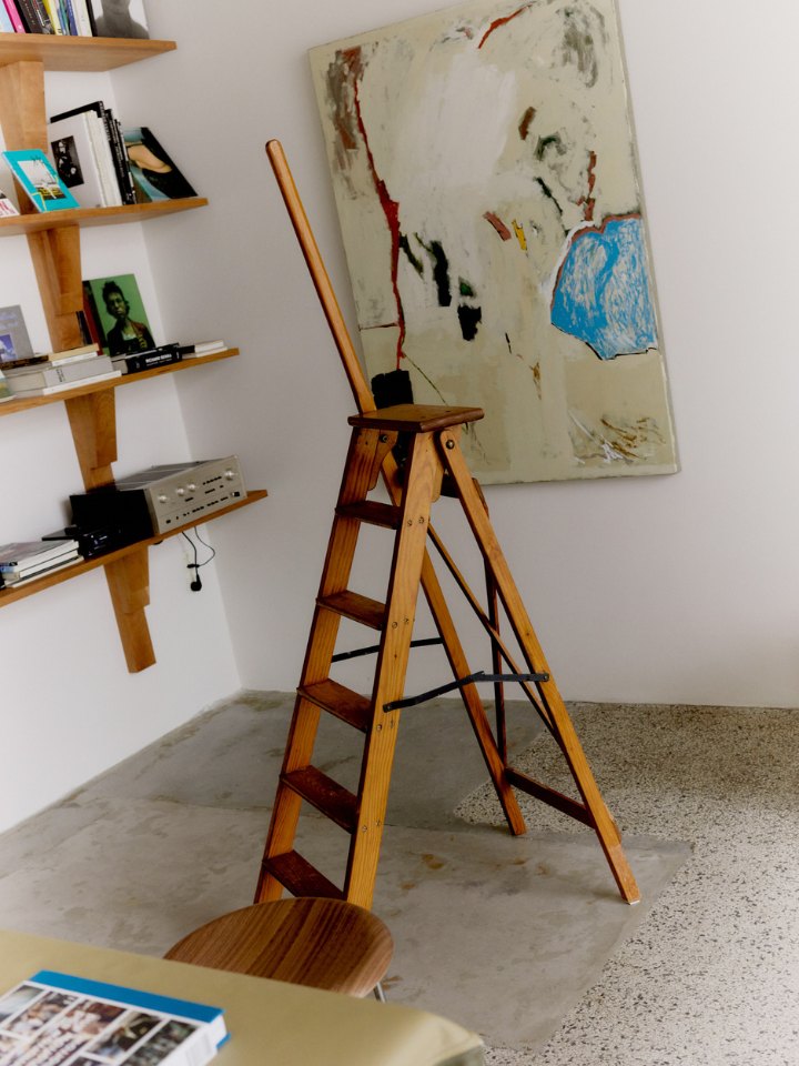 A wooden library ladder in front of a painting at Simone