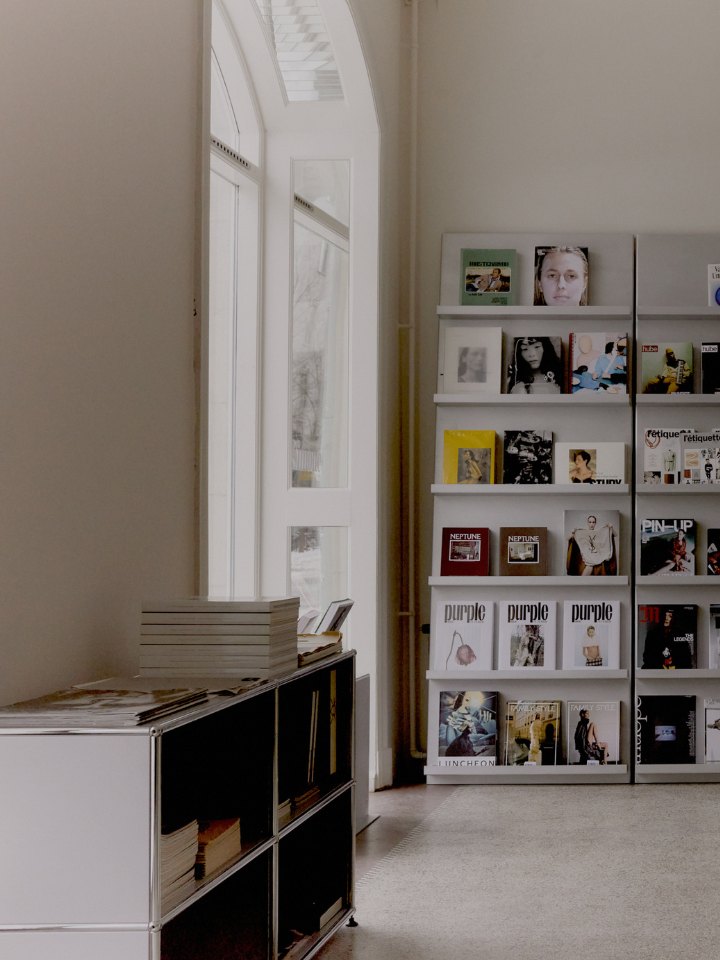 The magazine wall beside the tall arched window at Simone